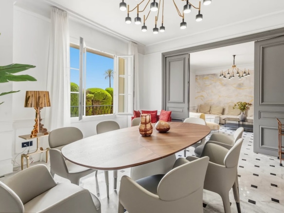 Intérieur d'un appartement à Cannes avec salle à manger moderne et vue sur l'extérieur.