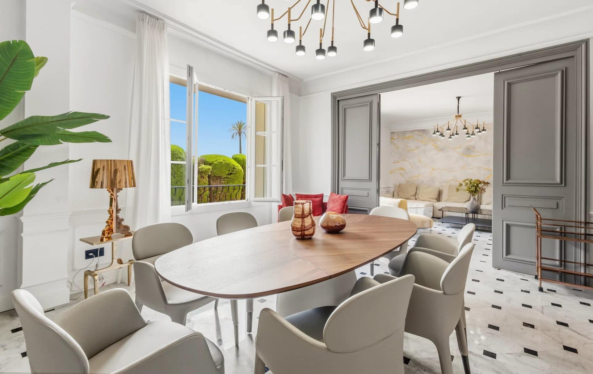 Intérieur d'un appartement à Cannes avec salle à manger moderne et vue sur l'extérieur.