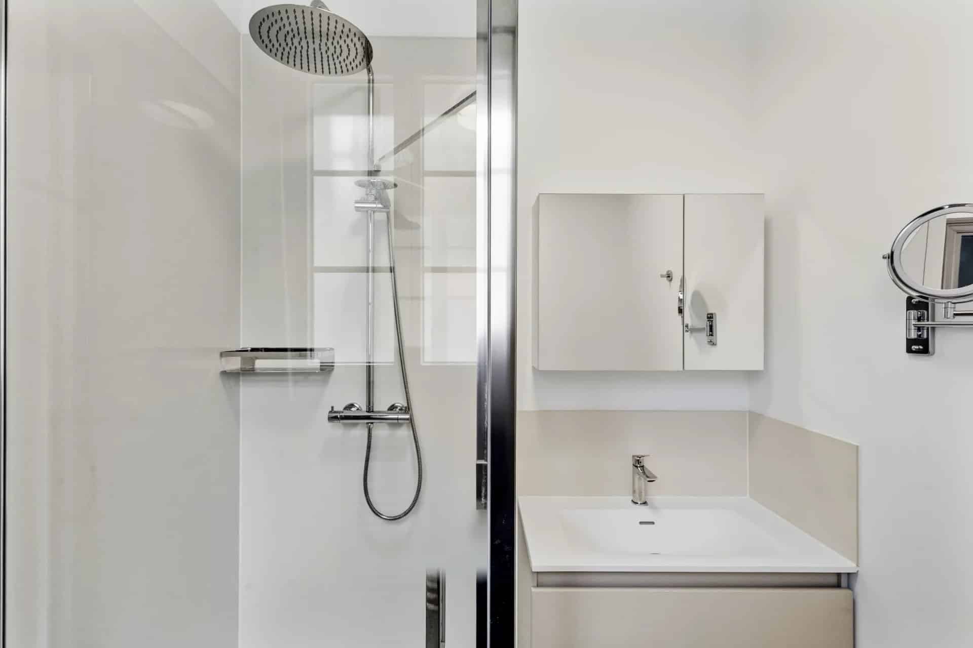Salle de bain moderne avec douche et lavabo dans un appartement à Cannes.