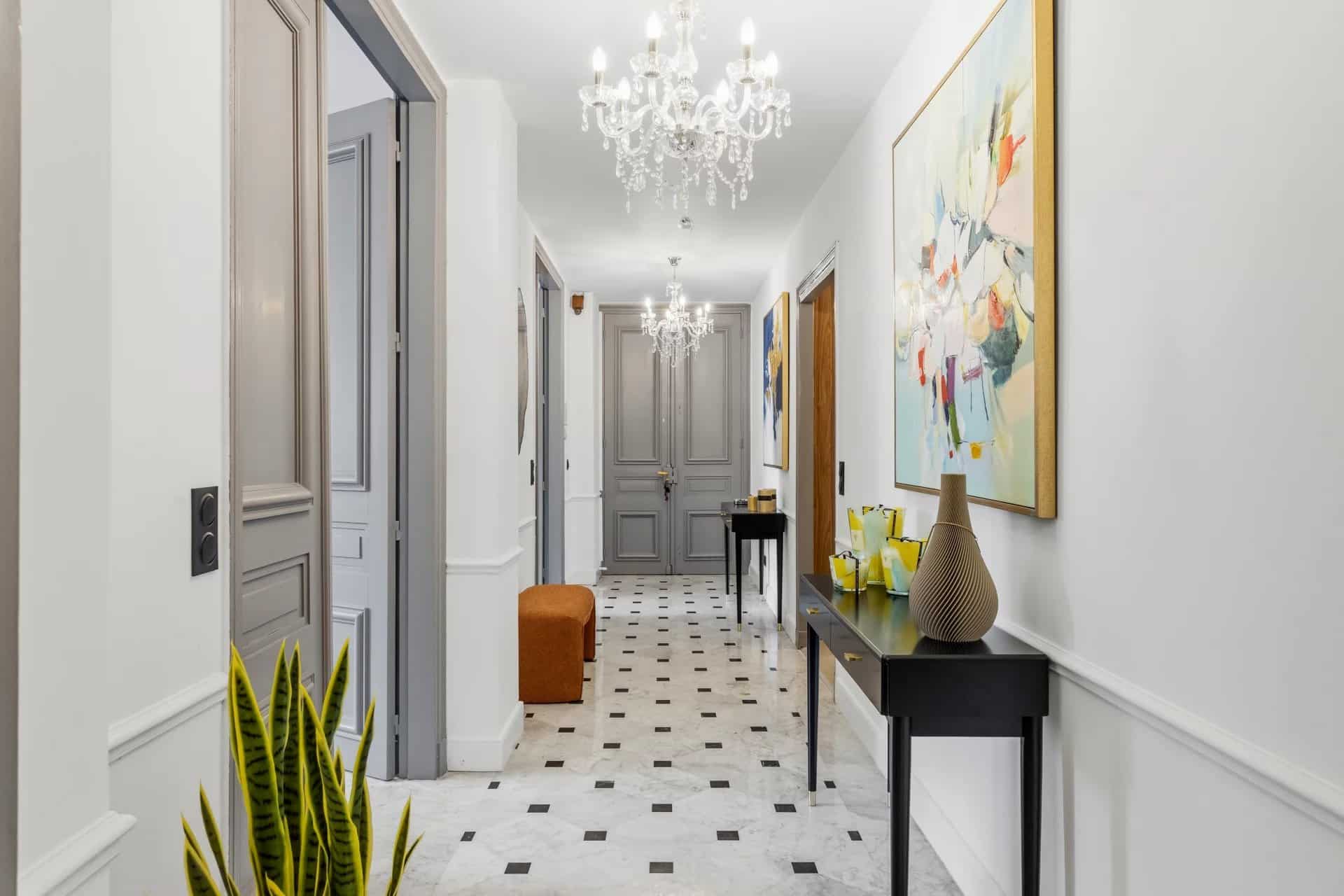 Intérieur d'un appartement à Cannes avec un hall d'entrée décoré et des lustres.