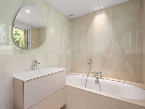 Salle de bain moderne avec baignoire et lavabo dans un appartement rénové.