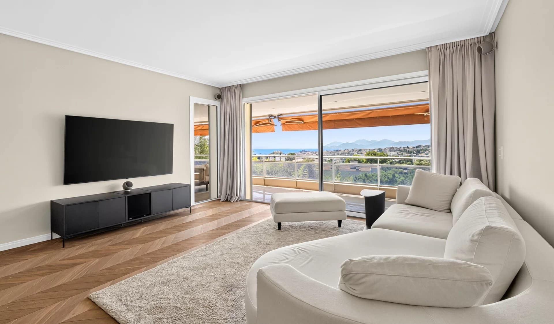 Salon lumineux d'un appartement 3 pièces avec vue mer, terrasse et mobilier moderne.