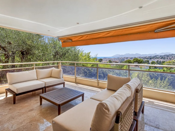 Terrasse d'un appartement à Le Cannet avec vue sur la mer et les collines, mobilier d'extérieur confortable.
