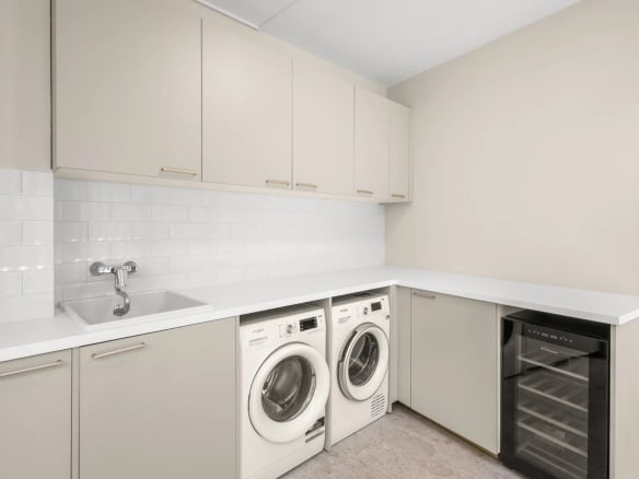 Cuisine moderne avec lave-linge et réfrigérateur dans un appartement rénové.