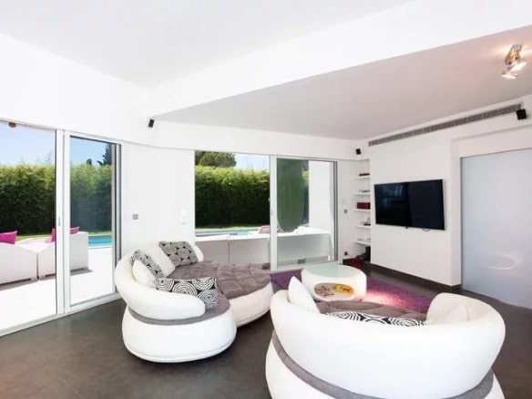 Interior of a detached villa in Mougins with a modern living room and a view of the swimming pool.