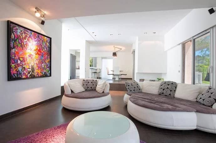 Interior of a detached villa in Mougins with a modern living room and a colorful piece of art on the wall.