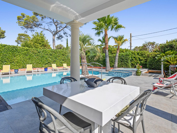 Terrasse avec piscine et jacuzzi dans une villa à Mougins, entourée de verdure.