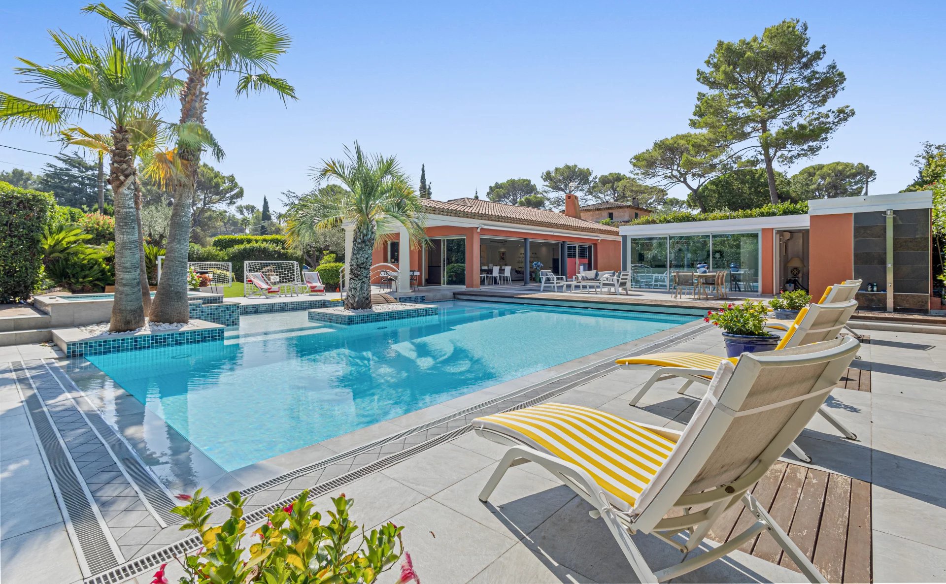 Villa avec piscine à Mougins Villa individuelle de plain-pied avec piscine et jacuzzi à Mougins, entourée de palmiers.