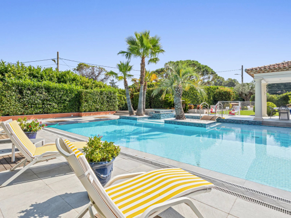 Villa individuelle avec piscine et jacuzzi, entourée de palmiers et de verdure à Mougins.