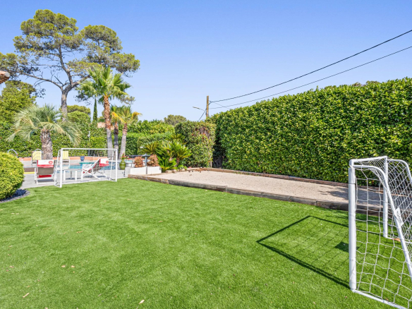Jardin avec pelouse et but de football, entouré de haies et d'arbres, à Mougins.