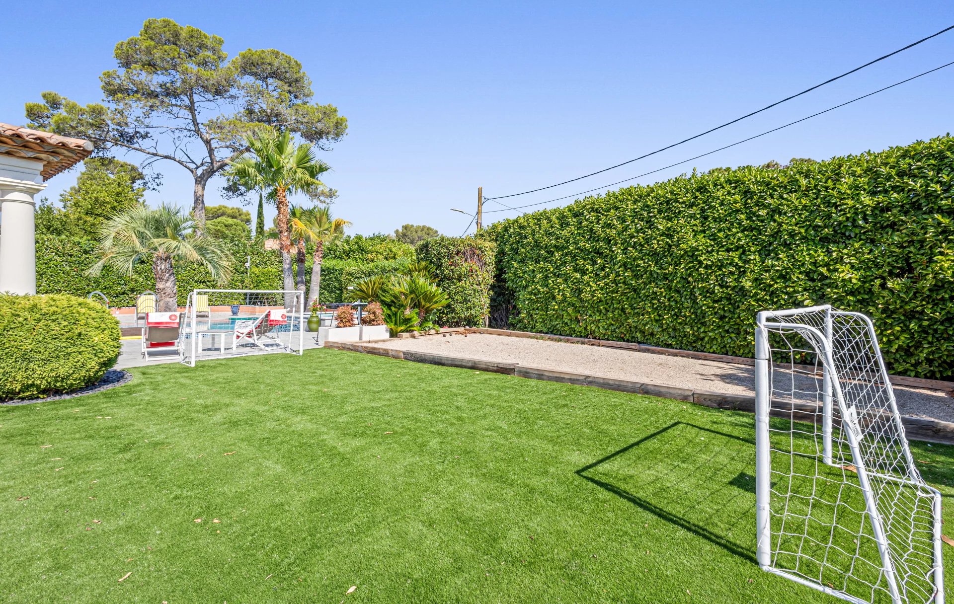 Jardin de la villa à Mougins Jardin avec pelouse et but de football, entouré de haies et d'arbres, à Mougins.
