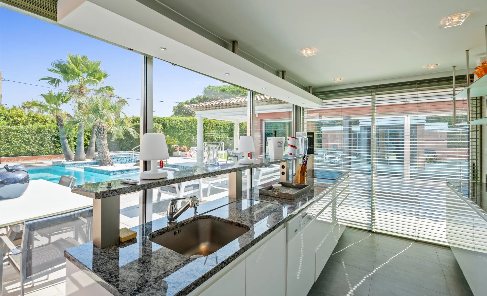 Cuisine de la villa à Mougins Intérieur d'une villa moderne avec cuisine équipée et vue sur la piscine extérieure