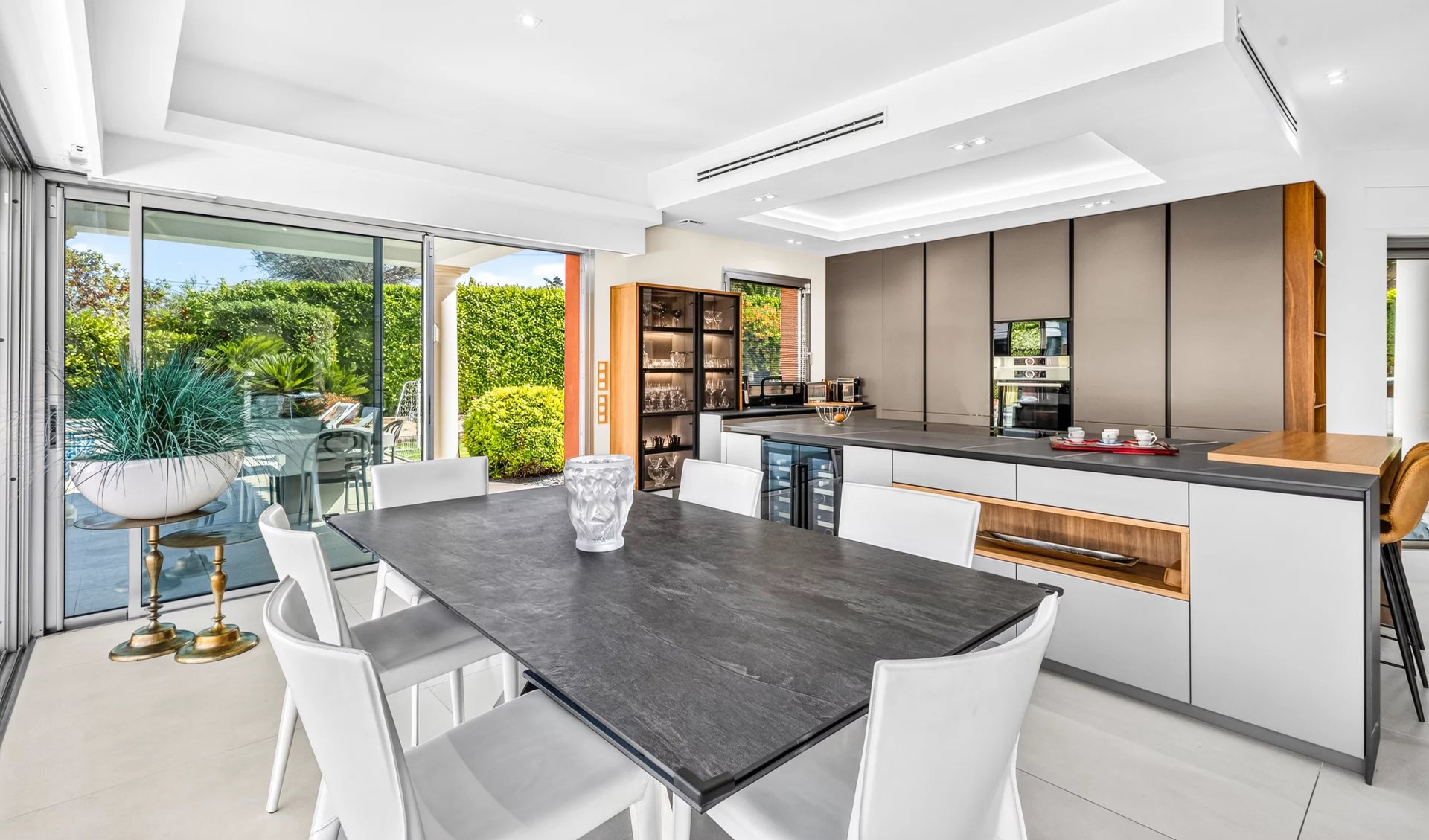 Cuisine moderne dans une villa à Mougins Cuisine moderne et lumineuse avec salle à manger, ouvrant sur l'extérieur et la piscine.