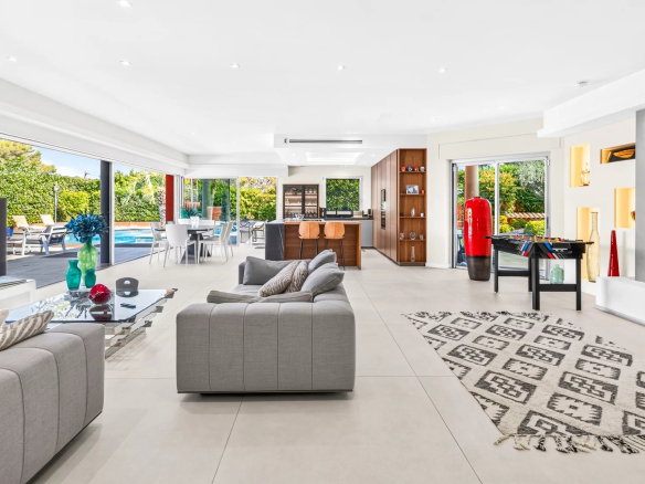 Intérieur d'une villa moderne à Mougins avec salon, cuisine et accès à la piscine extérieure.