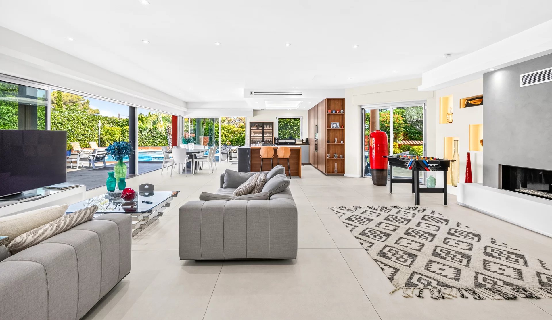 Intérieur d’une villa à Mougins Intérieur d'une villa moderne à Mougins avec salon, cuisine et accès à la piscine extérieure.