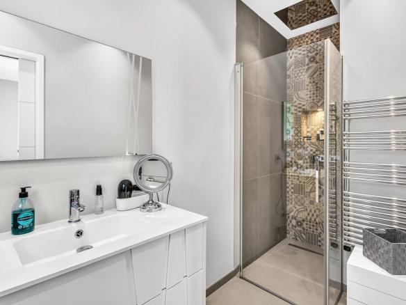 Salle de bain moderne avec douche, miroir et lavabo dans une villa à Mougins.