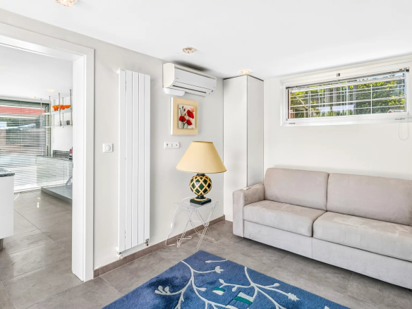 Intérieur d'une villa à Mougins avec un salon lumineux et un canapé gris.
