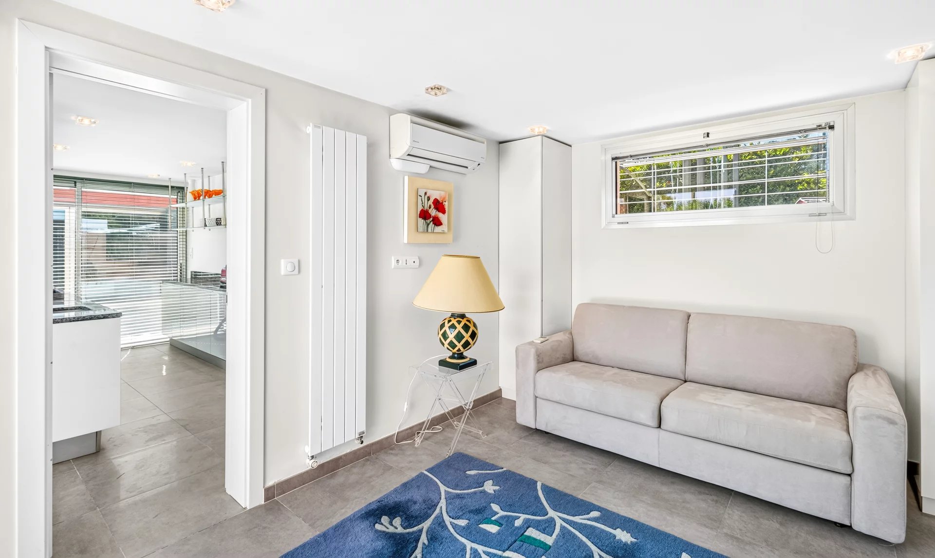 Intérieur d’une villa à Mougins Intérieur d'une villa à Mougins avec un salon lumineux et un canapé gris.