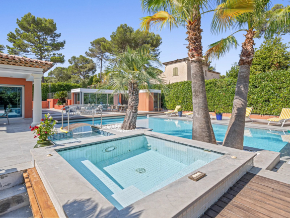Villa individuelle avec piscine et jacuzzi, entourée de palmiers dans un quartier résidentiel à Mougins.