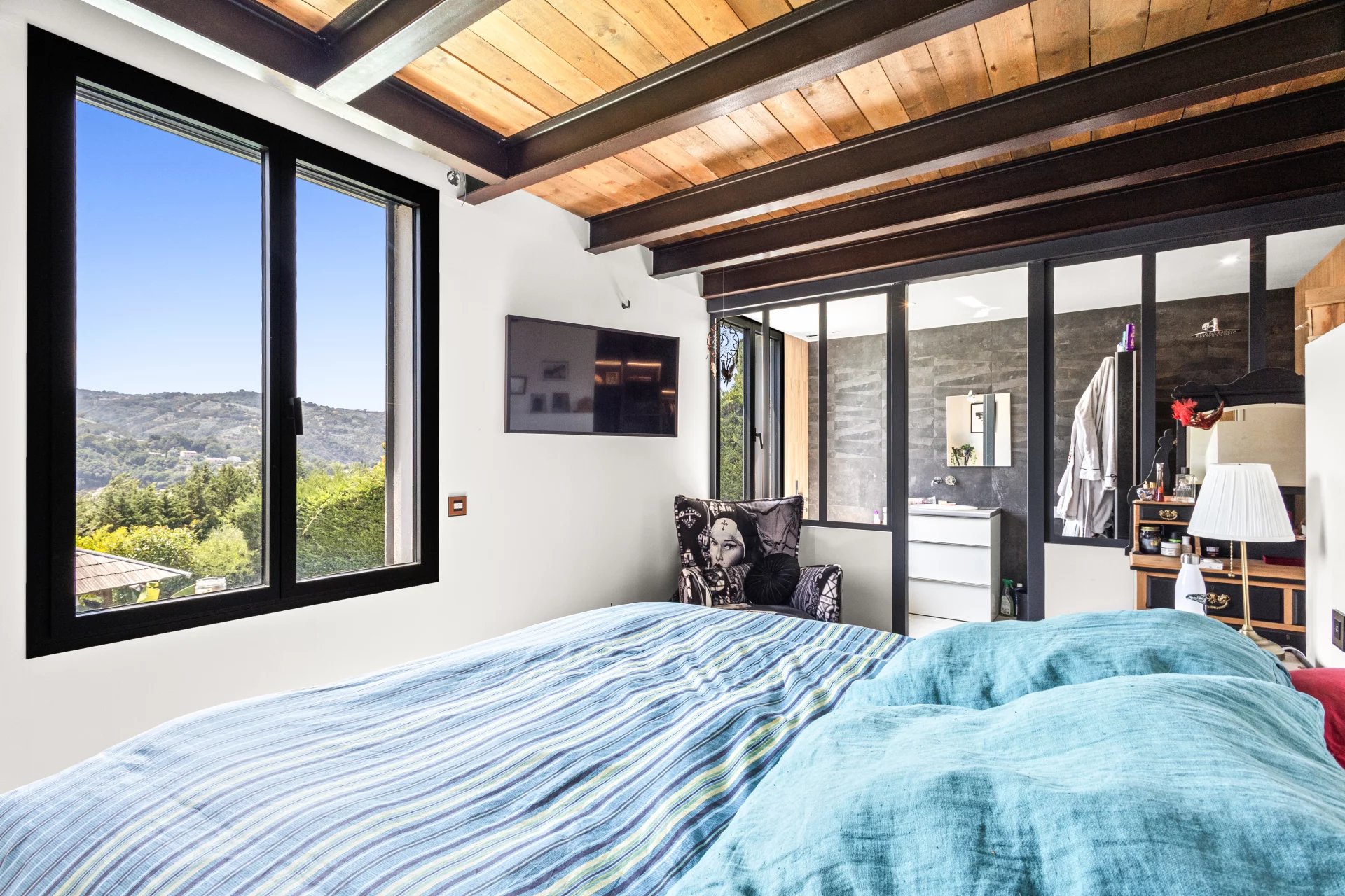 Villa room in Auribeau-sur-Siagne Room in a modern villa with nature view, bed and wall-mounted television.