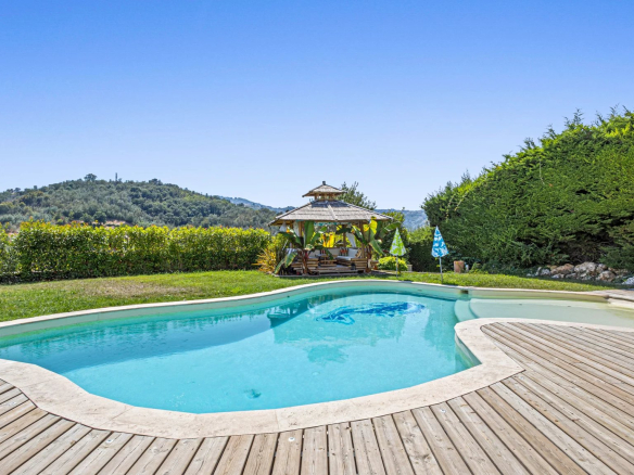 Villa with swimming pool and terrace in Auribeau-sur-Siagne, surrounded by greenery.