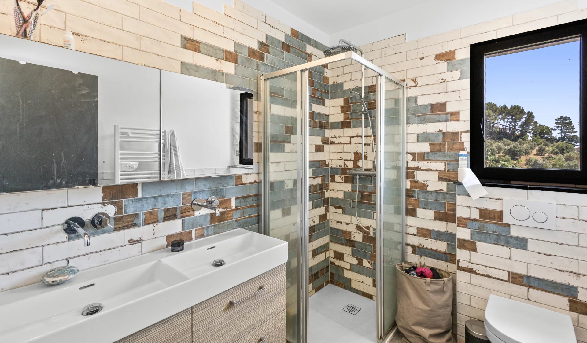 Bathroom of the villa in Auribeau-sur-Siagne Modern bathroom with glass shower and mosaic tiles.