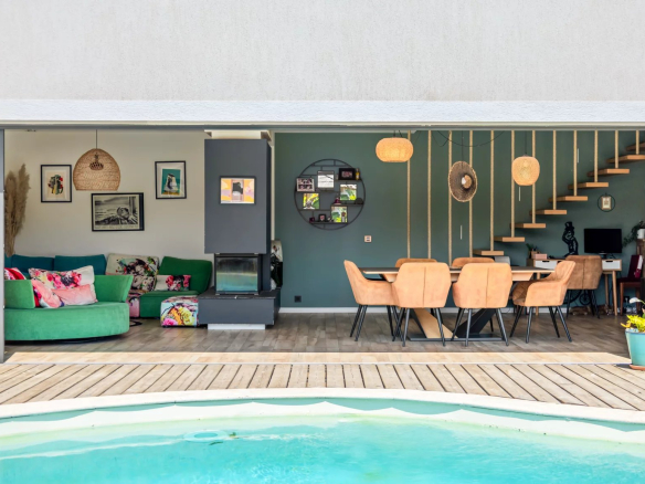View of the interior of a modern villa with swimming pool, living room and dining room.