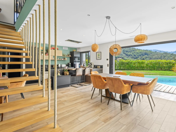 Interior of a modern villa with dining room, equipped kitchen and access to the swimming pool.