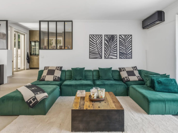 Intérieur d'une villa moderne avec un salon spacieux et un canapé vert.