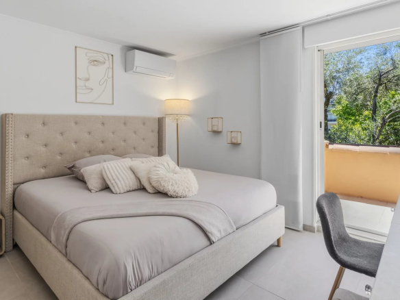 Chambre d'une villa moderne avec lit king-size et accès à un balcon.