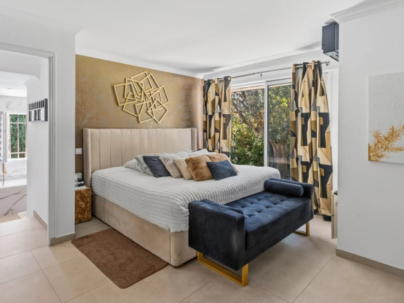 Chambre d'une villa moderne avec lit king-size et décoration contemporaine.