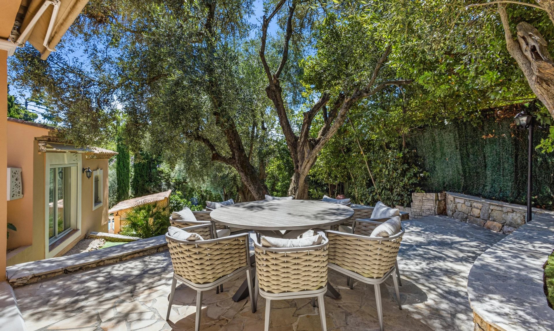 Terrasse de villa au Cannet Terrasse avec table et chaises entourée d'arbres dans une villa au Cannet.