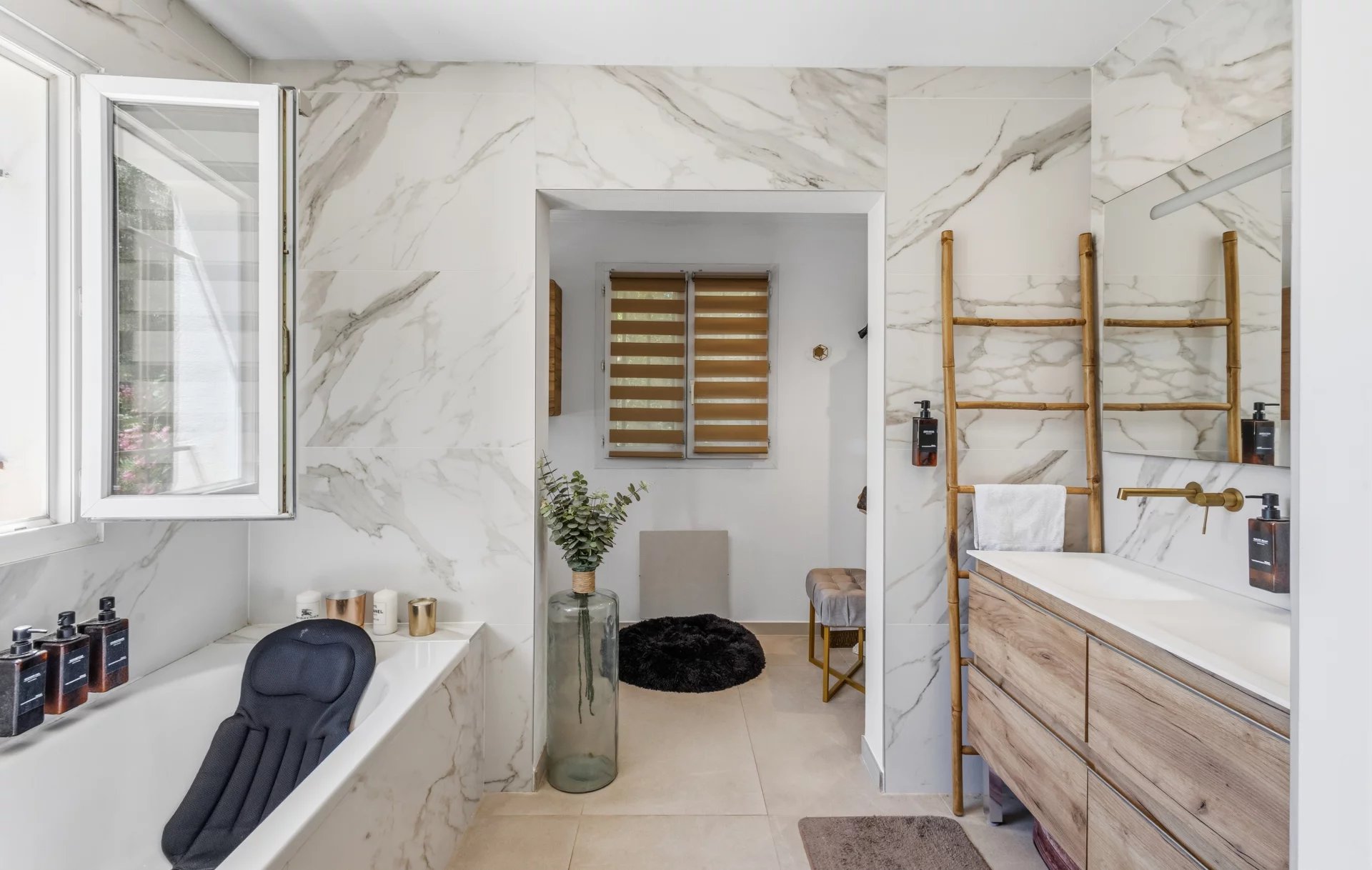 Salle de bain élégante dans une villa au Cannet Salle de bain moderne avec baignoire et meuble en bois, décorée de marbre.
