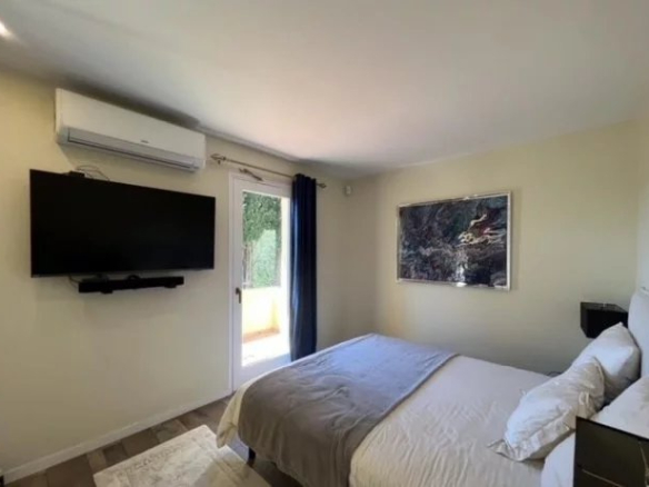 Room in a villa in Cannes with double bed, wall-mounted television and access to a terrace.