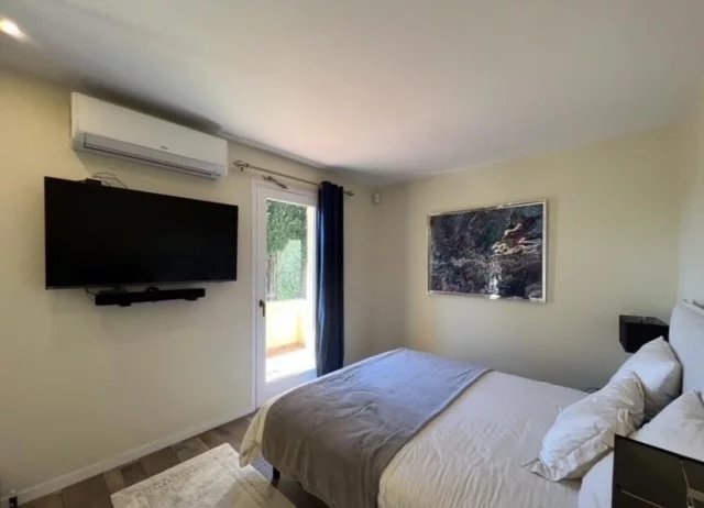 Room in a villa in Cannes with double bed, wall-mounted television and access to a terrace.