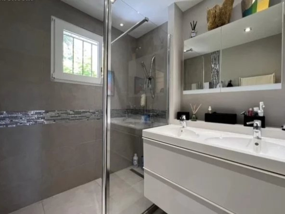 Modern bathroom with shower and double sink in a villa in Cannes.