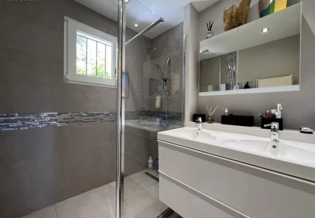 Modern bathroom with shower and double sink in a villa in Cannes.