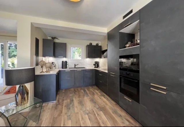 Modern and fully equipped kitchen in a villa in Cannes, with wooden furniture and integrated appliances.