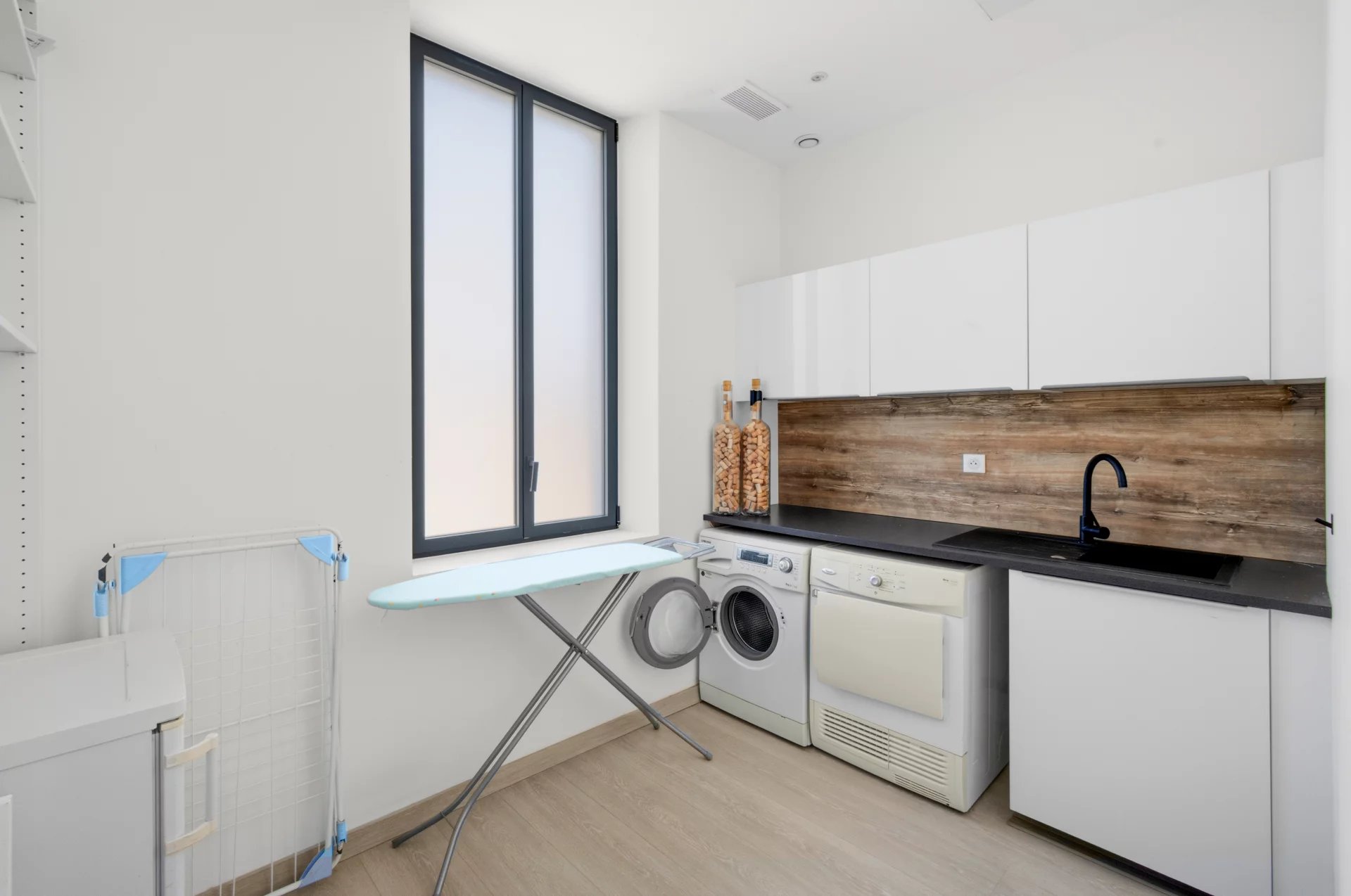Laundry room of a villa in Cannes Modern laundry room with washing machines and ironing board in a renovated villa in Cannes.