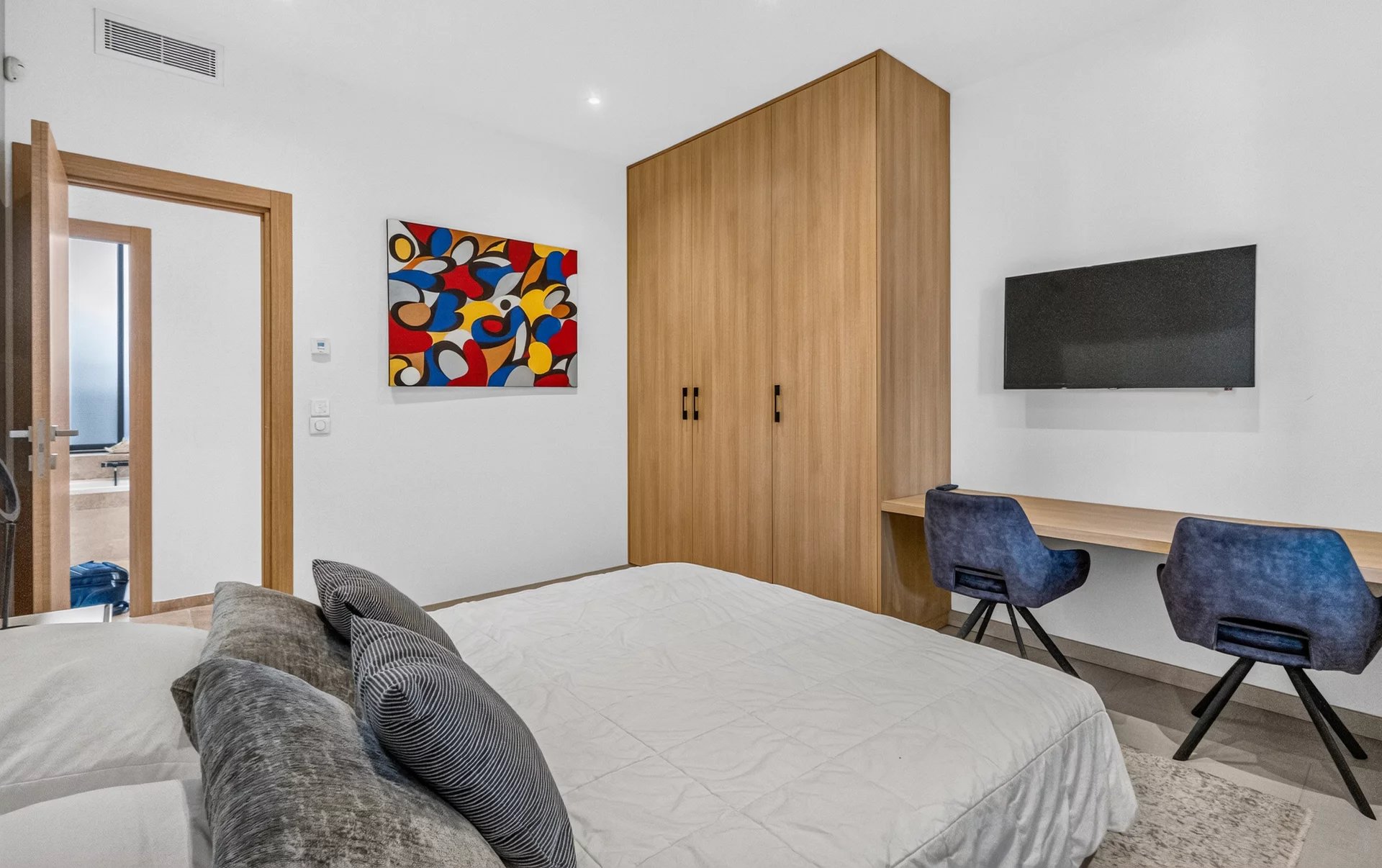 Villa room at Petit Juas Bedroom in a modern villa with bed, desk and wall-mounted television
