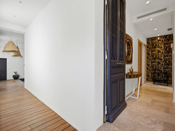 Interior of a renovated Belle Époque villa with a bright entrance hall and wooden flooring.
