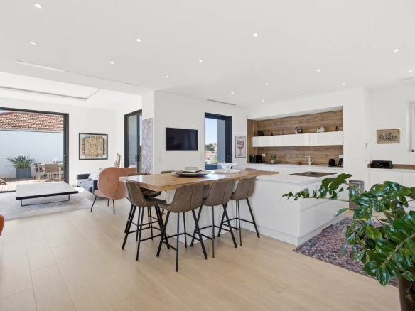 Interior of a renovated villa with open kitchen and bright dining room.