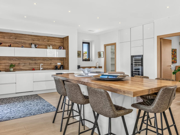 Modern and bright kitchen in a renovated Belle Époque villa in Cannes, with bar and dining area.