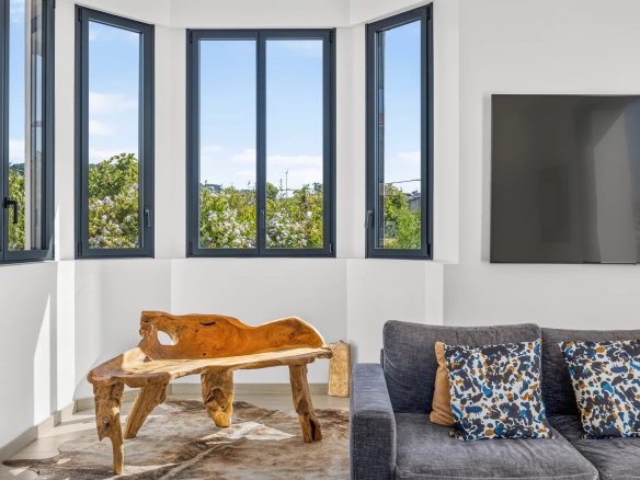 Interior of a modern villa with a bright living room and a wooden table, panoramic windows.