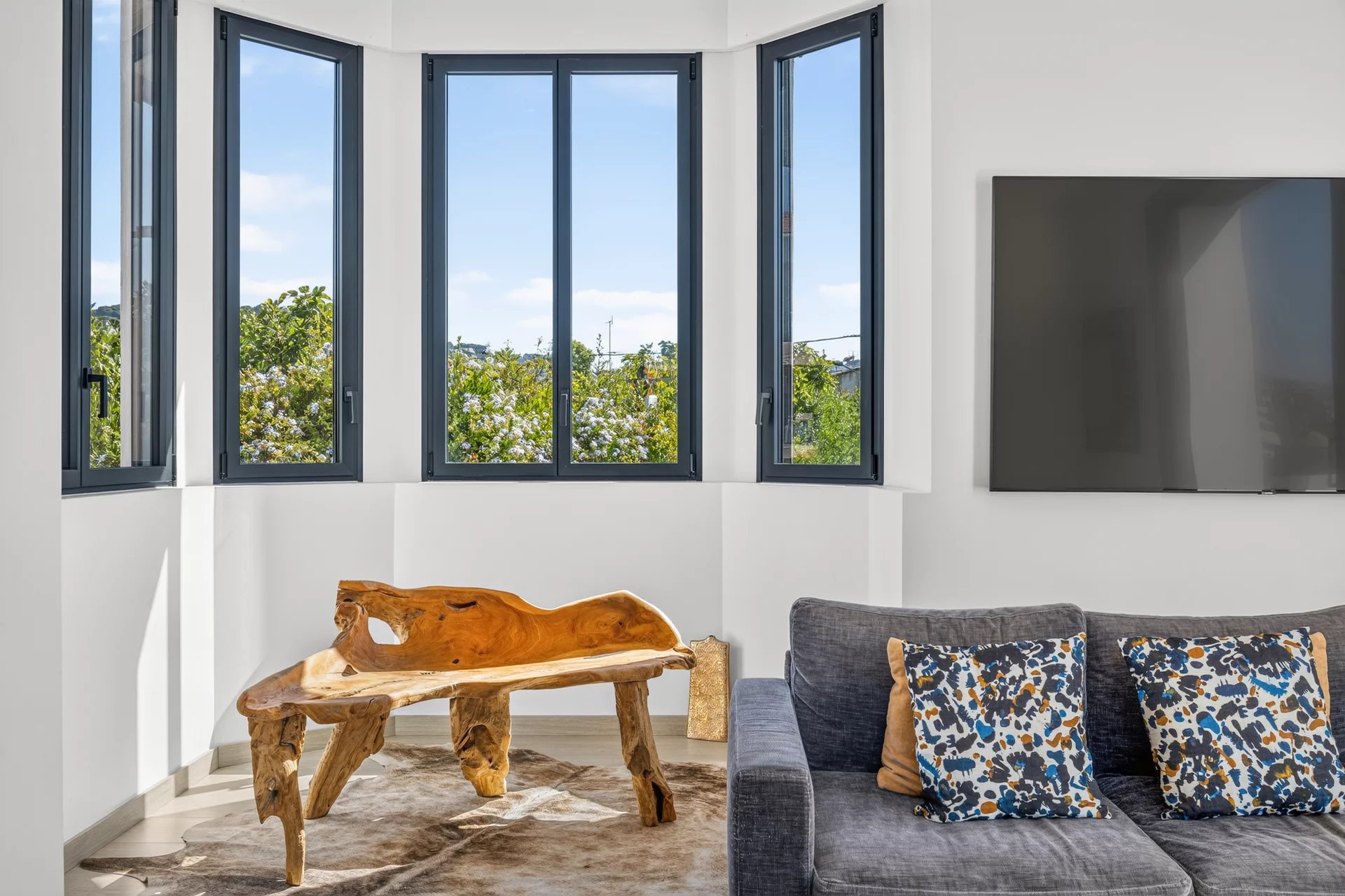 Interior of a villa in Petit Juas Interior of a modern villa with a bright living room and a wooden table, panoramic windows.