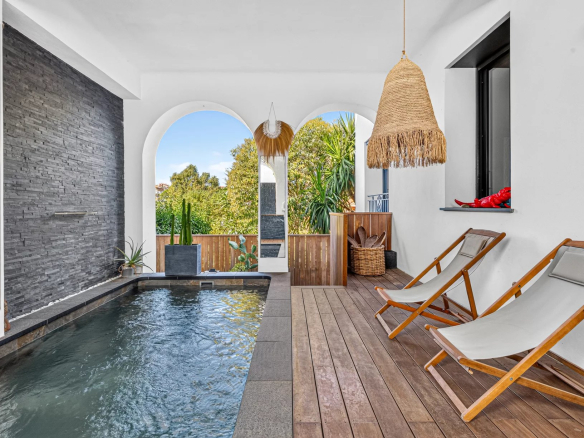 Interior of a renovated Belle Époque villa with swimming pool and sun loungers.