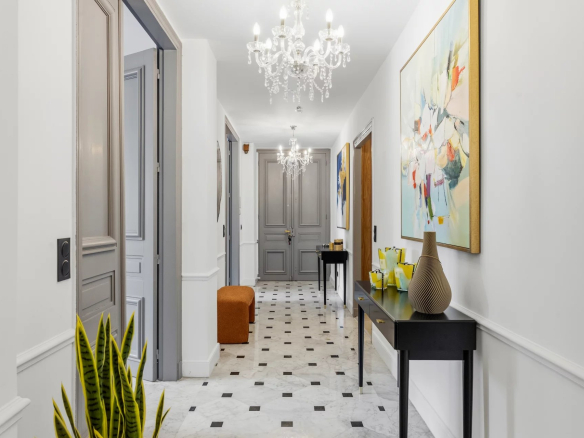 Intérieur d'un appartement à Cannes avec un couloir décoré et des lustres.