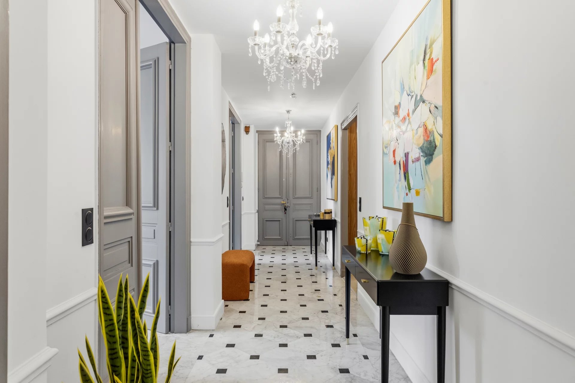 Couloir d’un appartement à Cannes Intérieur d'un appartement à Cannes avec un couloir décoré et des lustres.