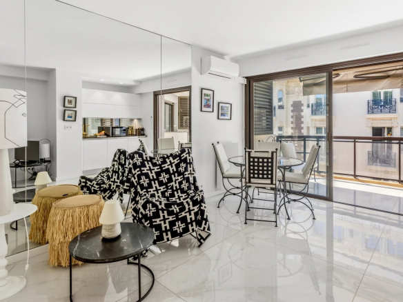 Interior of a renovated studio apartment with living room, equipped kitchen and terrace in Cannes.