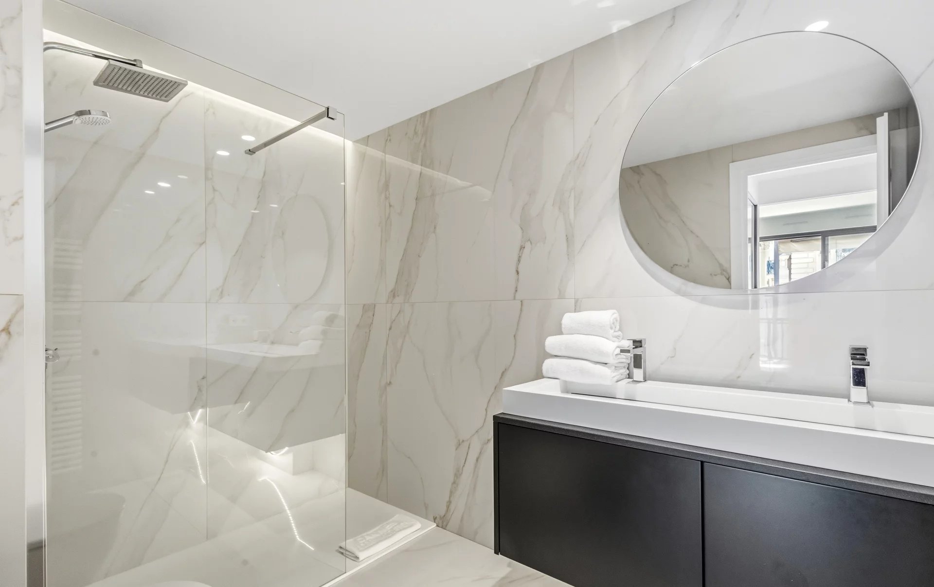 Shower room of the studio in Cannes Modern shower room with walk-in shower and sink in a renovated studio in Cannes.